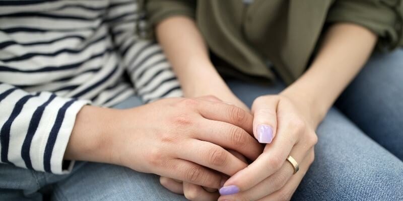 One person offering another a supportive hand, illustrating empathy and understanding.